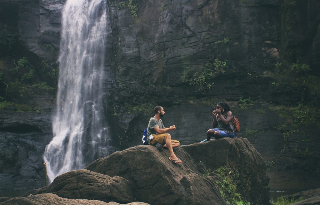 couples enjoying waterfall- a wonderful travel package by kerala travel agencies